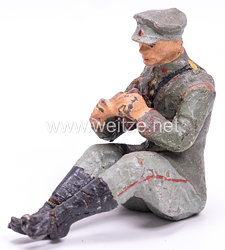 Elastolin - Heer Lagerleben - Soldat mit Schirmmütze sitzend Brot schneidend
