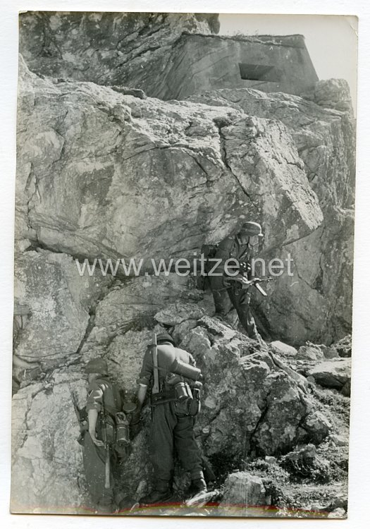 Wehrmacht Heer Pressefoto: Im Schutze des Geländes arbeitet sich der Sturmtrupp an den Felsbunker heran